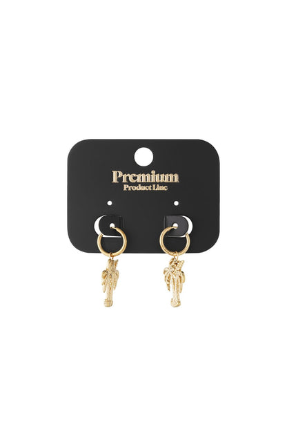 Gold hoop earrings with palm tree charms on a black display card.