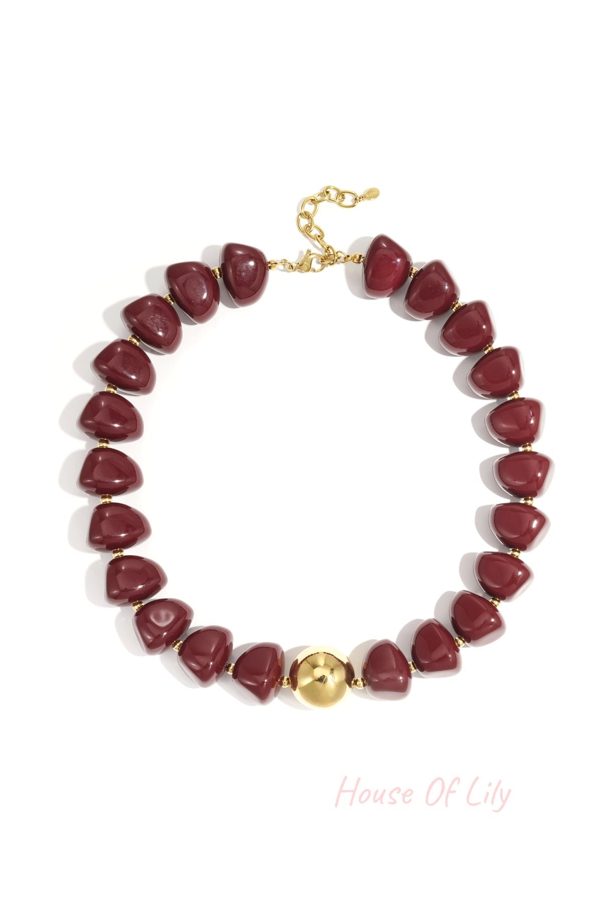 Close-up of a chunky burgundy beaded necklace with gold accent bead and clasp on white background