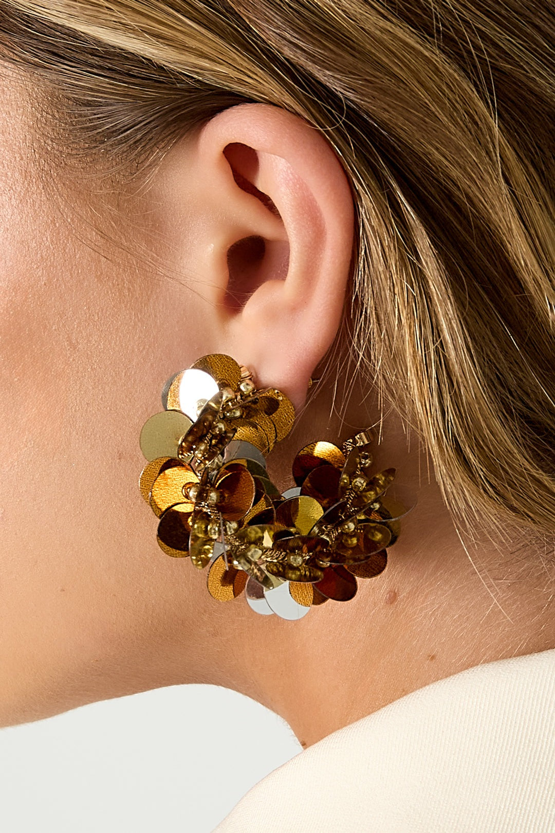 Model profile showing pink and silver iridescent sequin hoop earring with layered discs