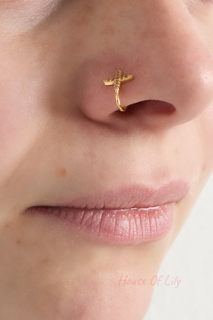 Gold nose cuff with sparkling cubic zirconia worn on a woman's nostril showcasing subtle, elegant style