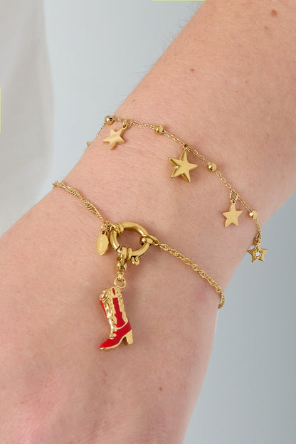 Close-up of a wrist wearing a gold star charm bracelet paired with a colorful boot charm bracelet