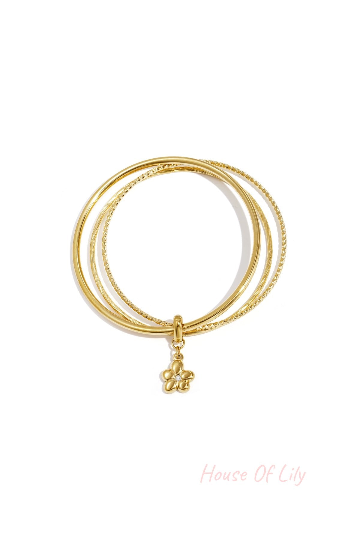 Set of two gold-tone bangles with a hanging flower charm on a white background