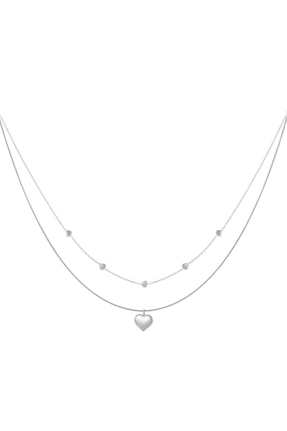 Silver double-layered necklace with small heart accents on one chain and a larger heart pendant on the other, isolated on white background