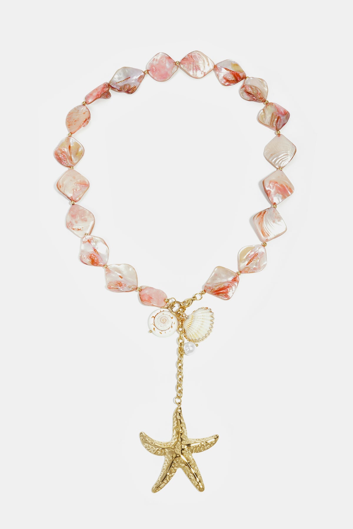 Pink and cream shell bead necklace with gold-tone starfish and shell charms laid flat on white background