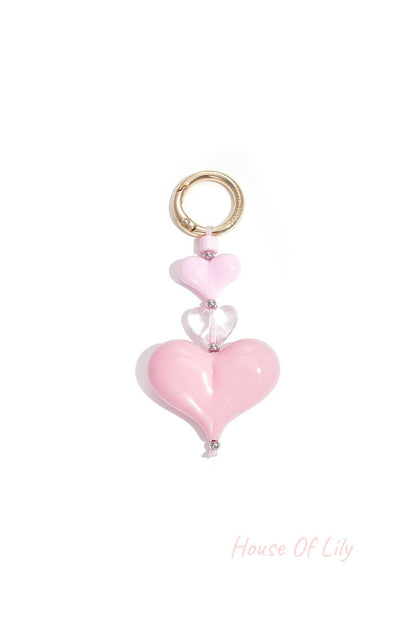 Pastel pink heart charm keychain with three acrylic hearts and gold-tone clasp on white background
