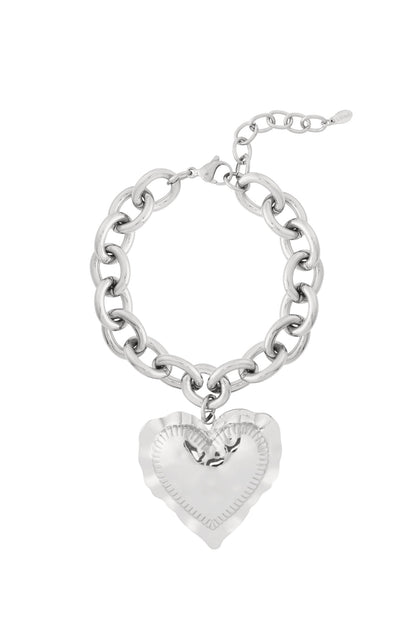 Silver chunky link bracelet with large hammered heart charm pendant on white background