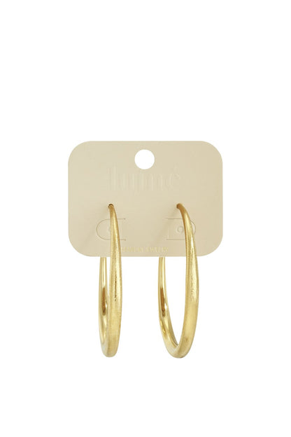 Aura Melt Hoops: Gold, circular hoop earrings with a textured, matte finish on a branded display card.