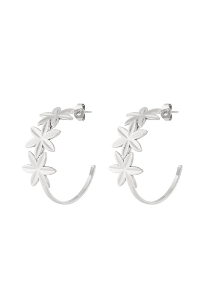 Pair of silver floral hoop earrings with three flowers on each hoop shown on white background