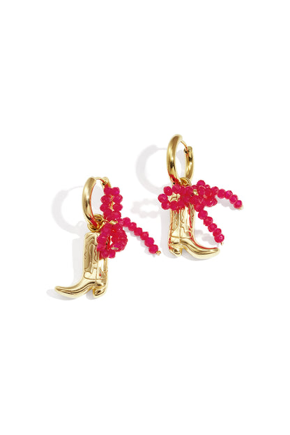Gold-tone cowboy boot drop earrings with a bright pink beaded bow detail