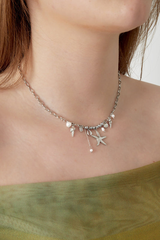 Model wearing the silver-tone seaside charm necklace styled with green outfit close-up