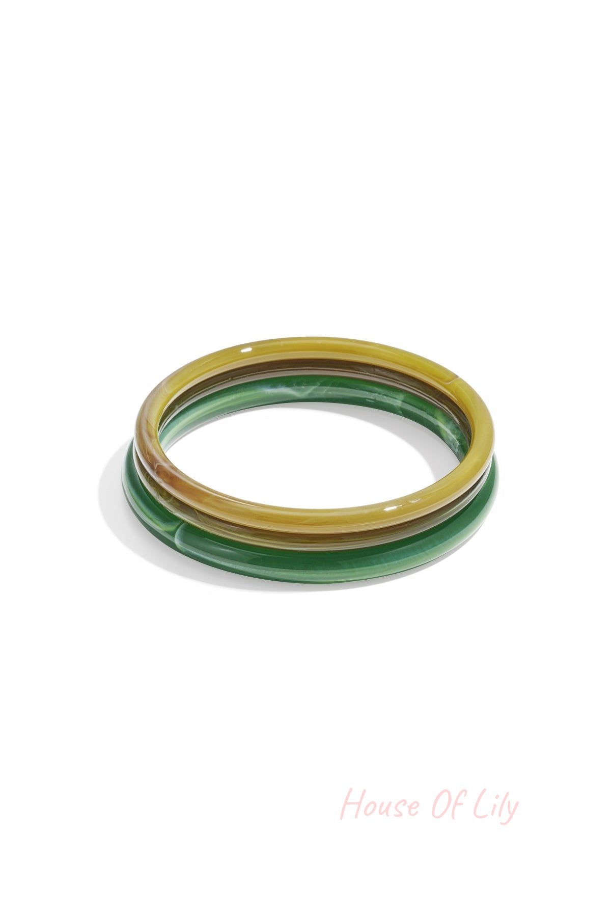 Three resin bangles in green and yellow tones showcasing a smooth polished look