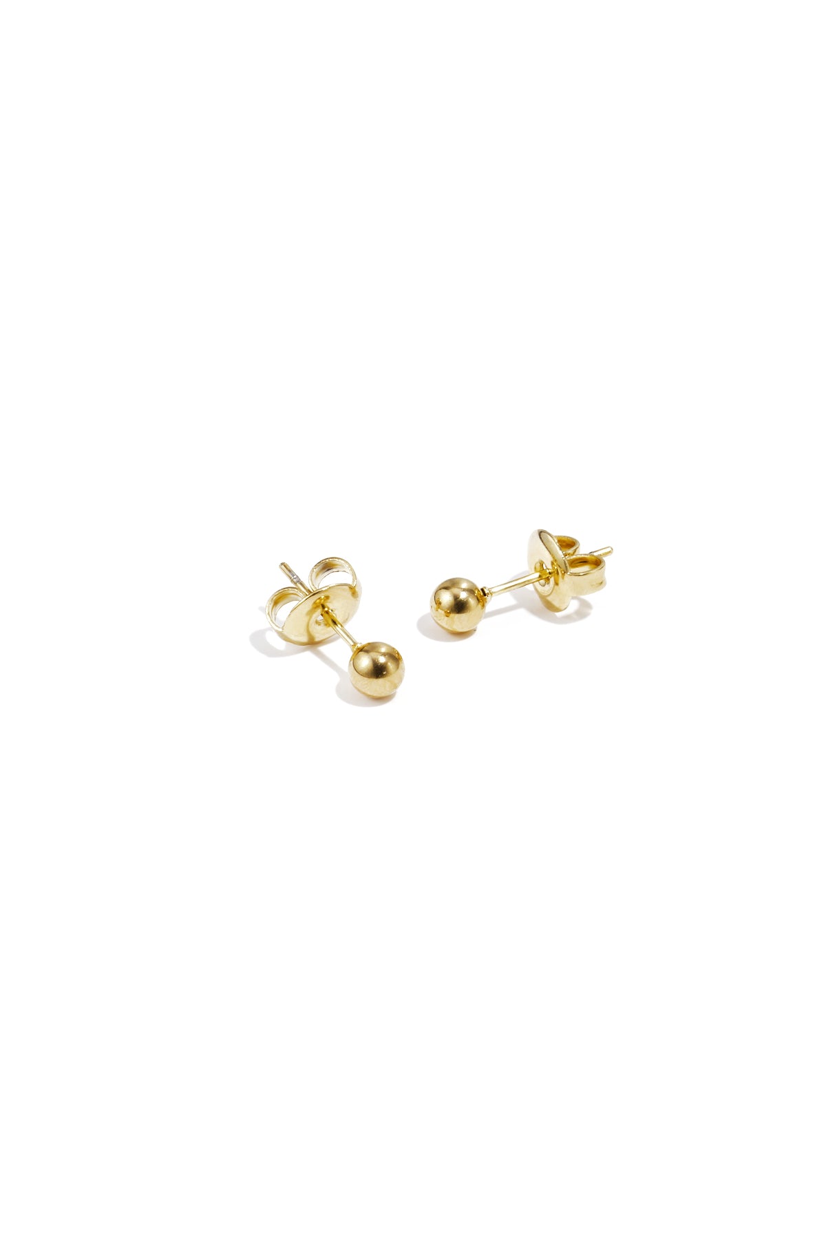 Pair of shiny gold dot stud earrings displayed on white surface