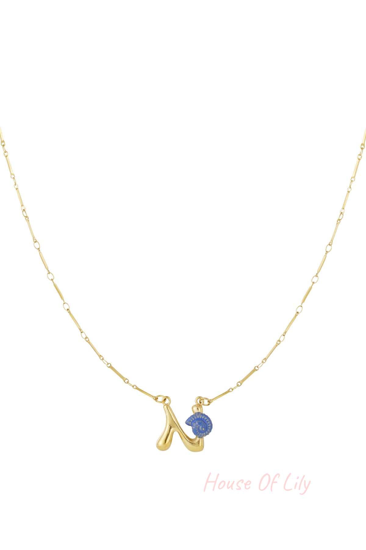 Gold chain necklace featuring a playful, puffed letter 'N' pendant accented with a small, blue spiral seashell charm.