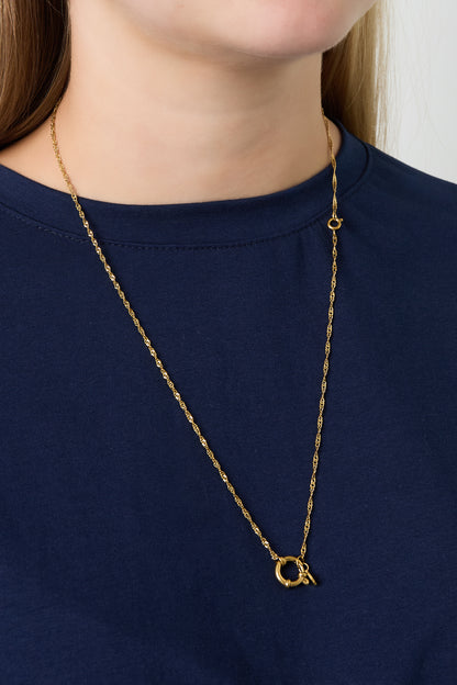 Model wearing gold chain necklace with a round spring ring clasp without charms over navy top