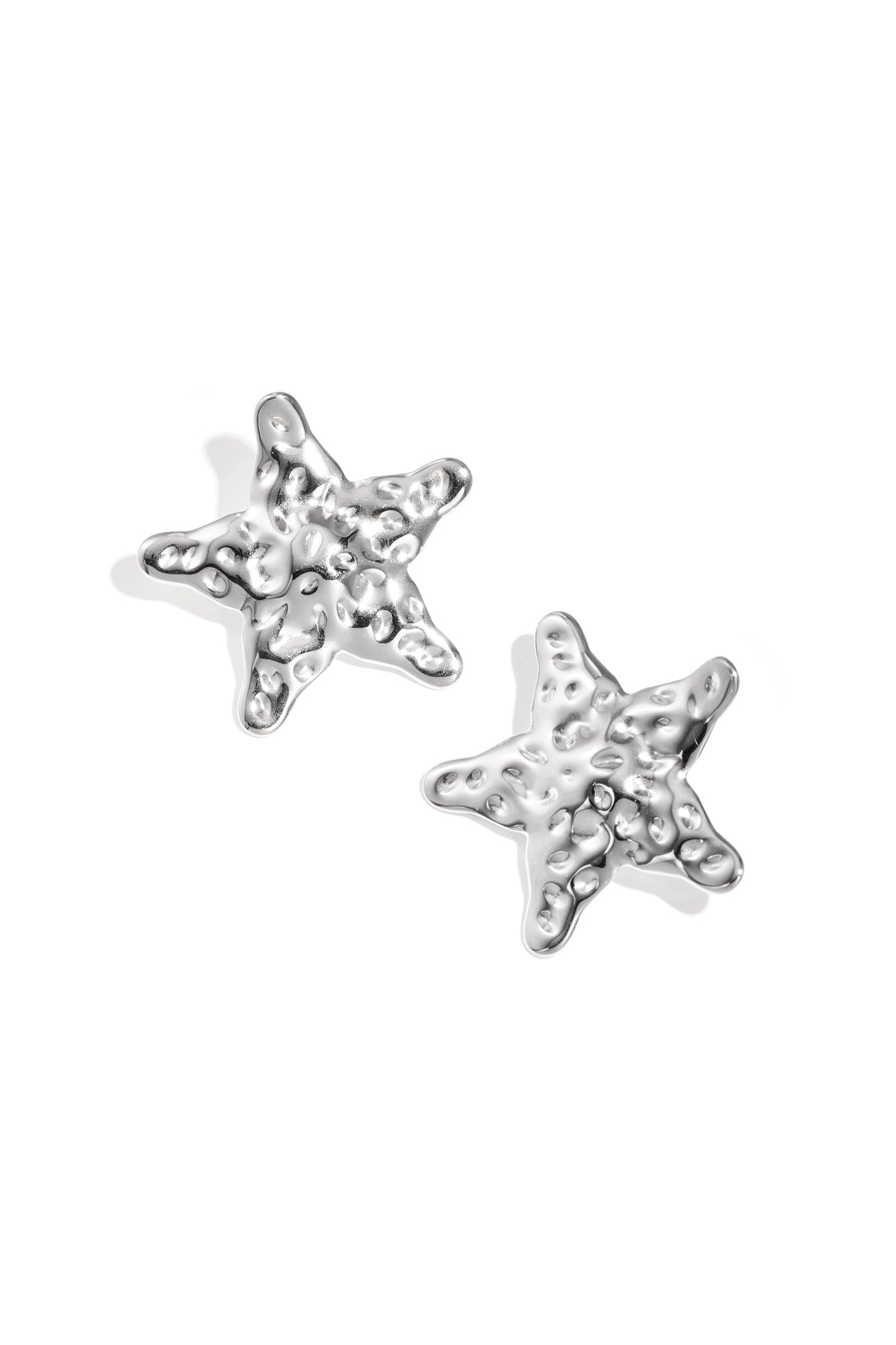 Close-up view of silver textured starfish-shaped stud earrings on white background