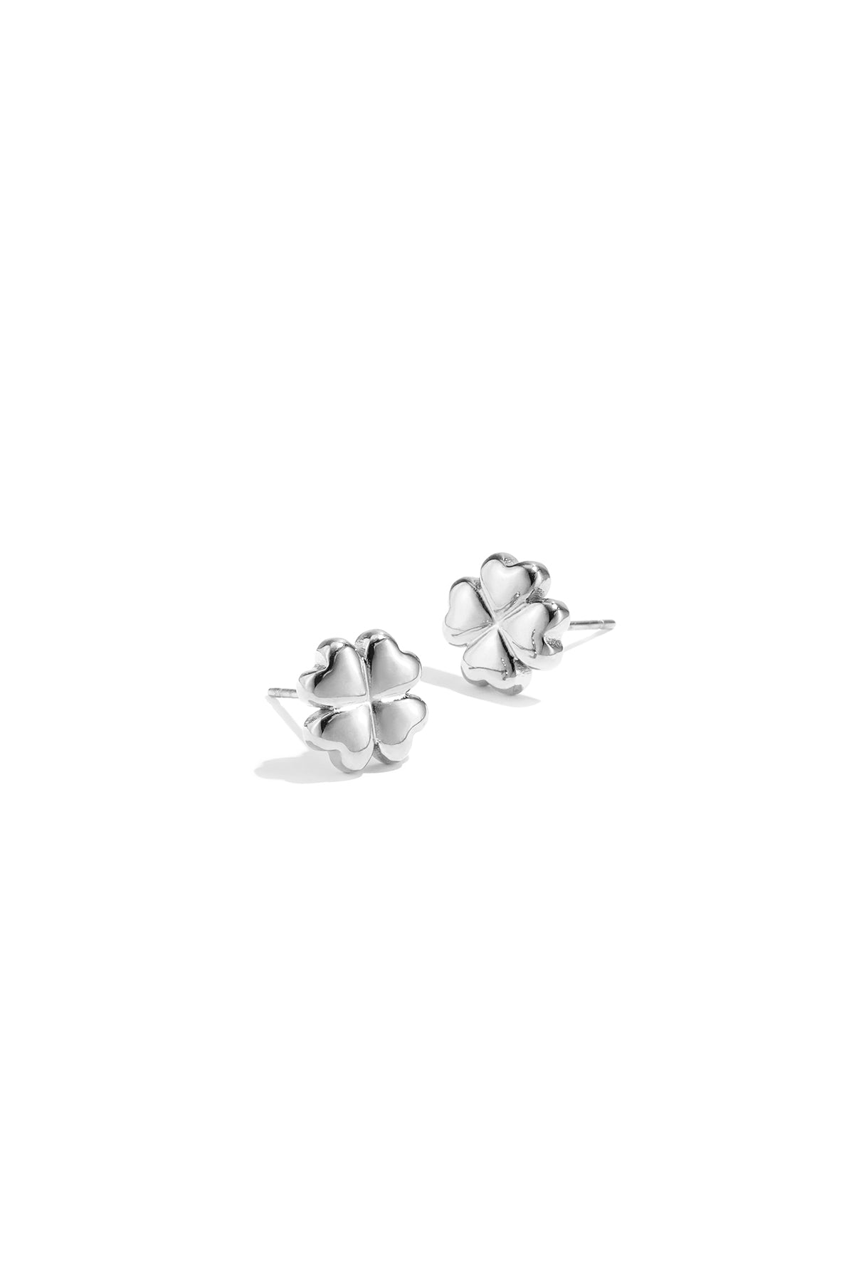 Pair of shiny silver four-leaf clover stud earrings on white background