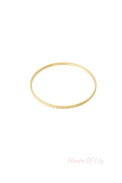 Minimalist gold textured bangle bracelet isolated on white background