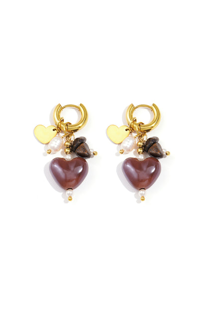 Pair of gold-tone hoop earrings with brown heart charms, natural stones, and faux pearls on white background