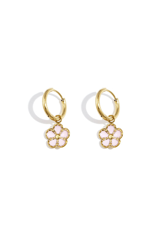 Pair of gold hoop earrings with delicate pink enamel flower charms displayed on a white background