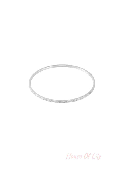 Close-up of a slender silver bangle with rhinestone accents on a white background