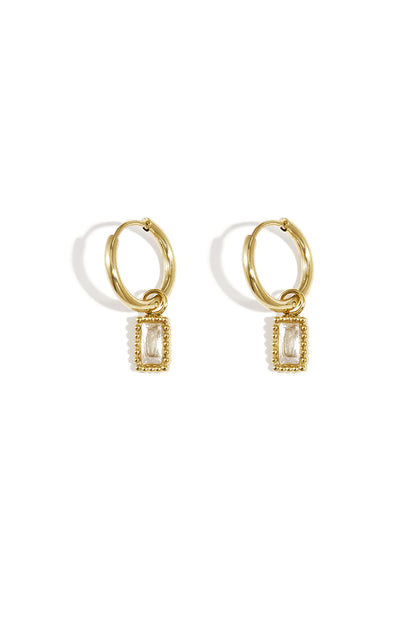 Pair of gold hoop earrings with clear rectangular gemstone charms on a white background