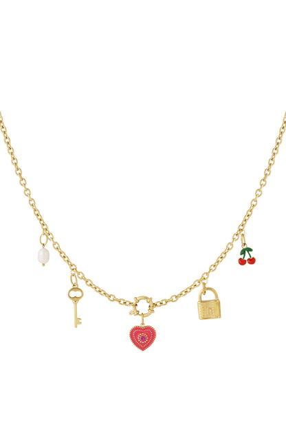 Close-up gold-plated charm necklace featuring pendants of a red heart, key, pearl, padlock and cherries neatly arranged on chain