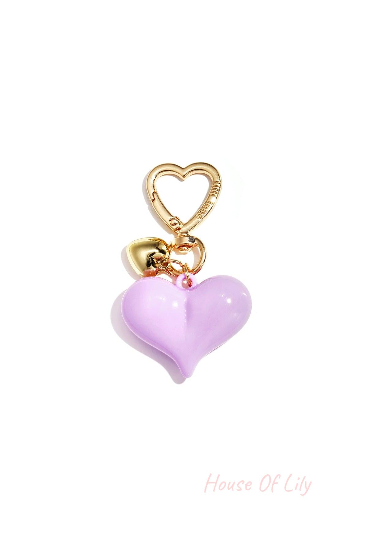 Single lavender acrylic heart bag charm with gold heart clasp and mini gold heart pendant on white background