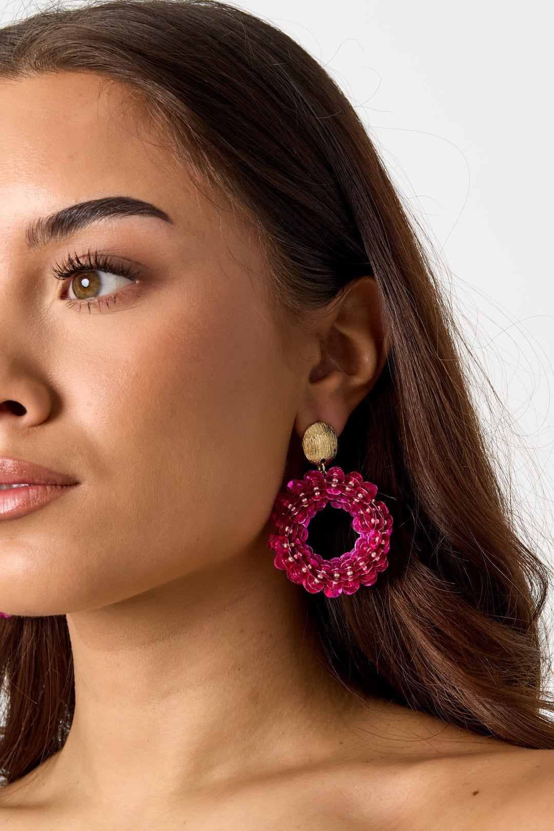 Drip In Disco earrings: Round, hot pink sequin-covered hoops with gold textured stud tops worn on a model.