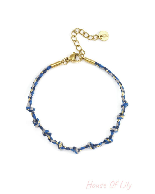 Charmed Cotton Chain bracelet with blue and grey knotted threads, gold-tone metal accents, and an adjustable chain clasp.