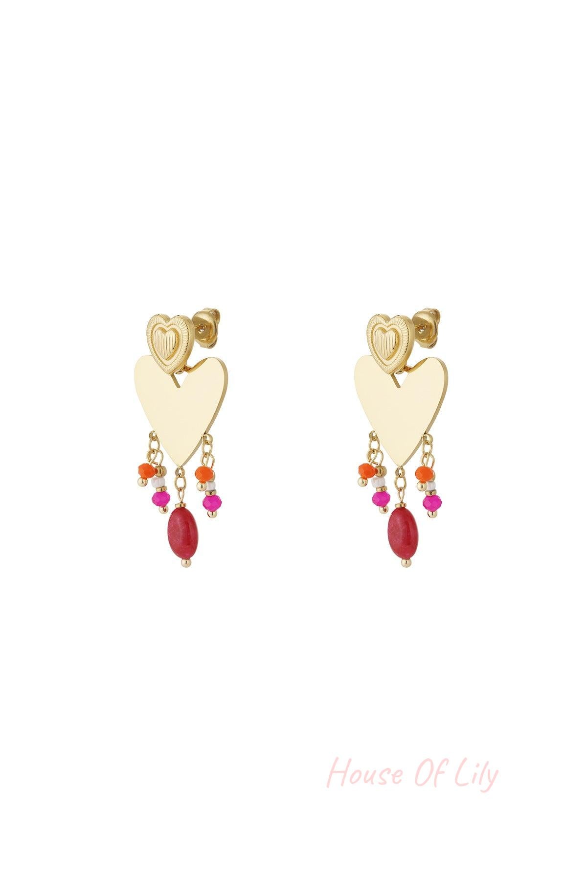 Pair of gold-tone heart drop earrings with colorful pink, orange, and red bead charms dangling below a textured smaller heart stud on white background.