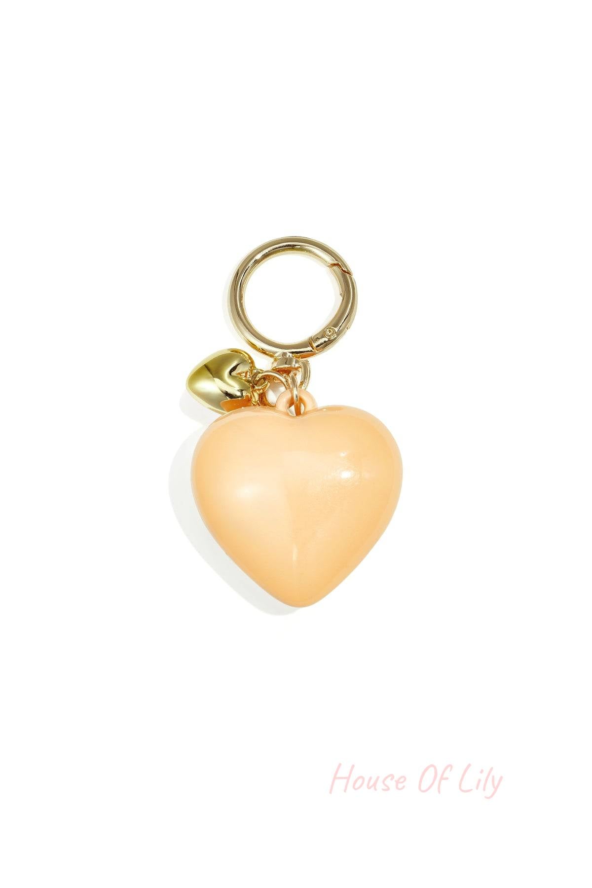 Glossy peach-colored heart-shaped acrylic bag charm with gold alloy ring and tiny heart charm