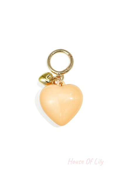 Glossy peach-colored heart-shaped acrylic bag charm with gold alloy ring and tiny heart charm