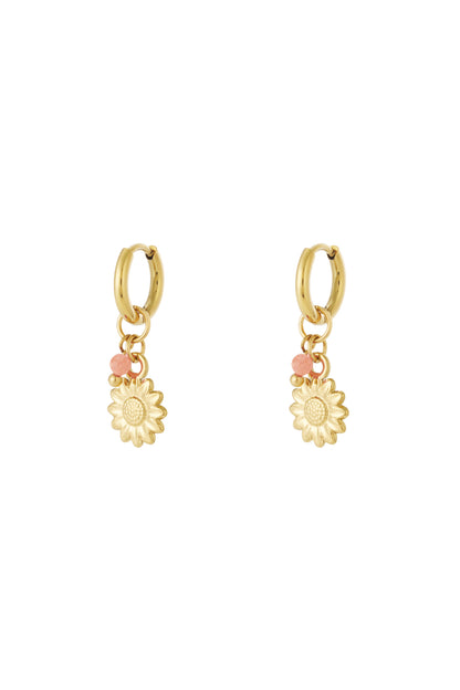 Pair of gold hoop earrings with sunflower charm and small peach bead accents displayed on white background