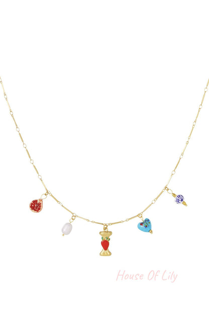 Gold-tone chain necklace with an initial pendant and charms including a pomegranate, pearl, heart, and floral bead.