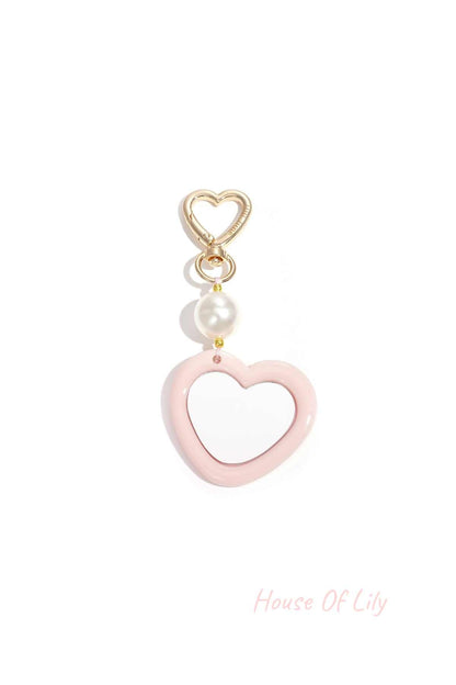 Gold heart clip with light pink acrylic heart charm and pearl bead on white background