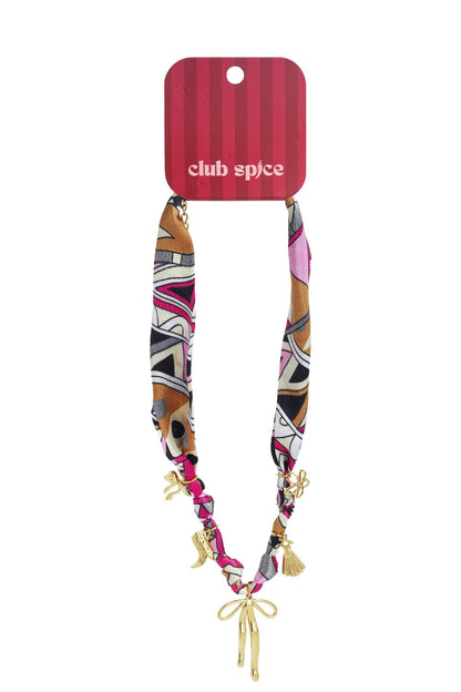 Scarf Tied Vibe necklace featuring a multi-colored geometric fabric scarf with dangling gold charms and a central bow.