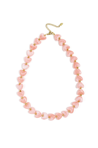 Pink heart-shaped beaded necklace with gold spacer beads on white background
