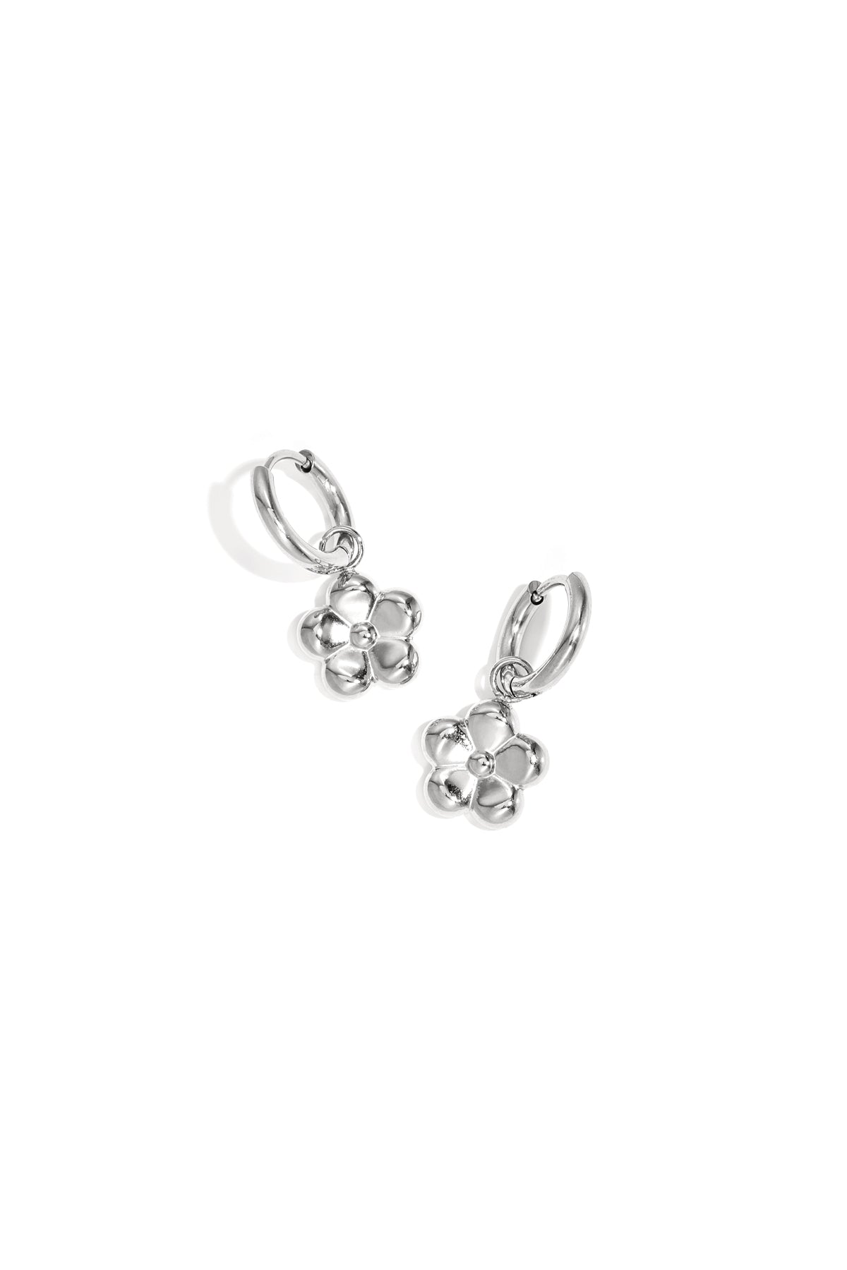 Silver flower pendant hoop earrings displayed on white background