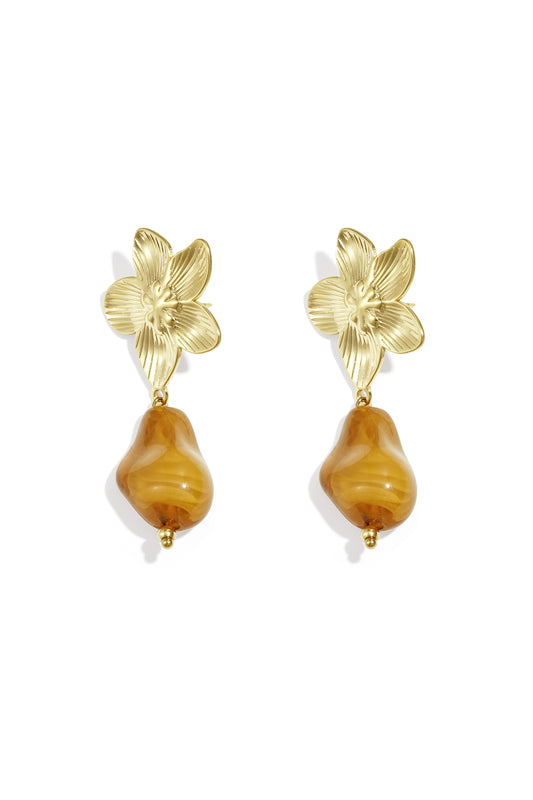 Pair of gold-tone flower drop earrings with amber organic acrylic bead on white background