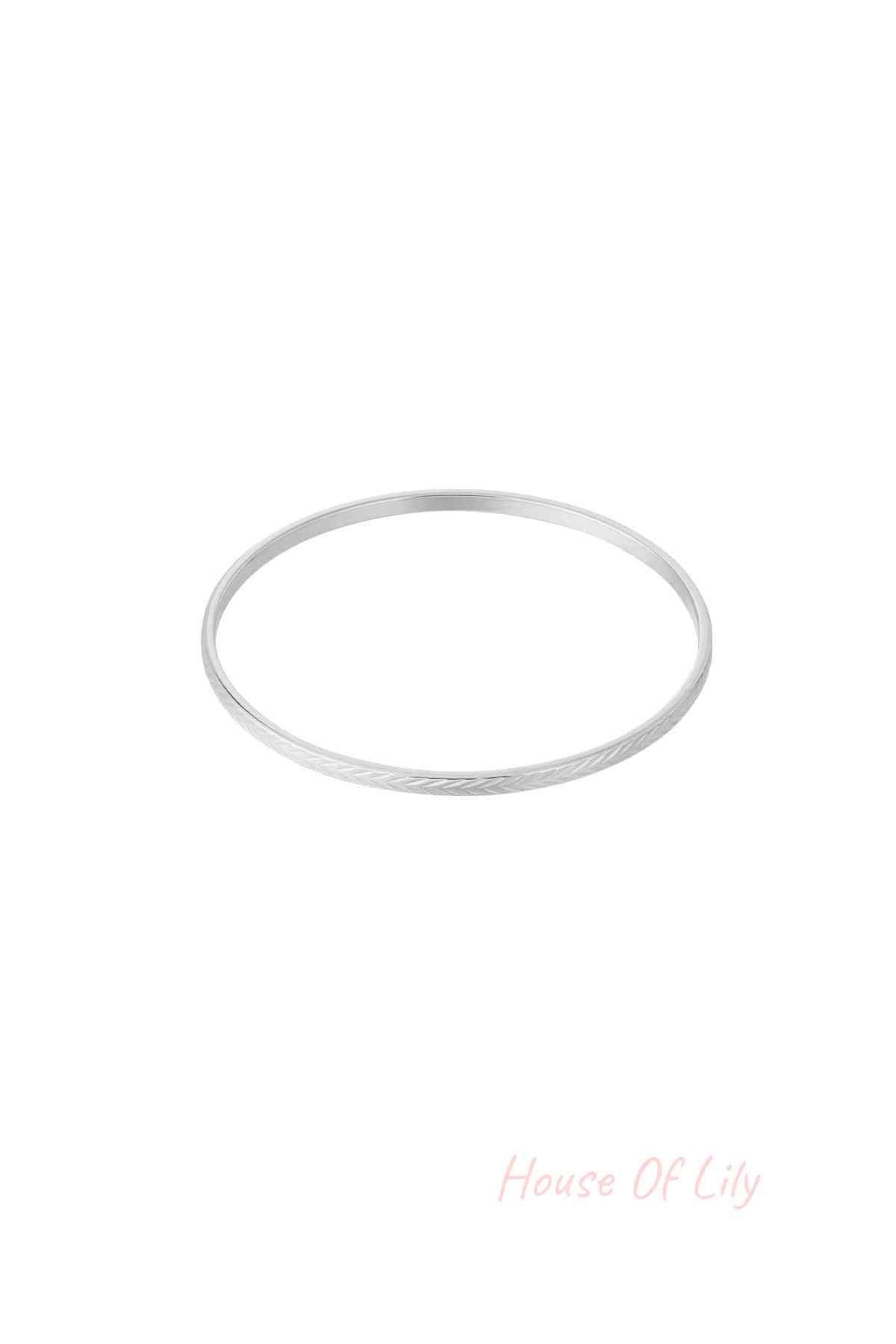 Silver textured bangle with fine etched pattern on white background