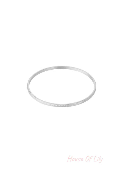 Silver textured bangle with fine etched pattern on white background