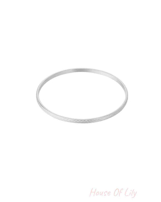 Silver textured bangle with fine etched pattern on white background