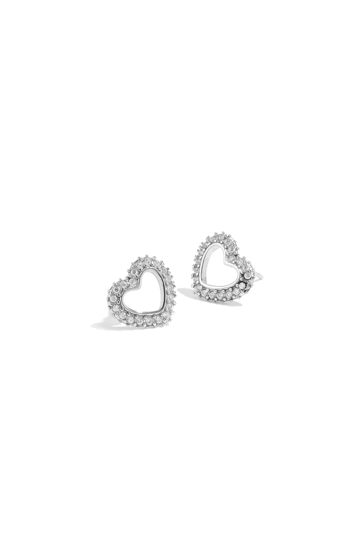 Close-up of silver-tone heart-shaped stud earrings with rhinestone accents on white background