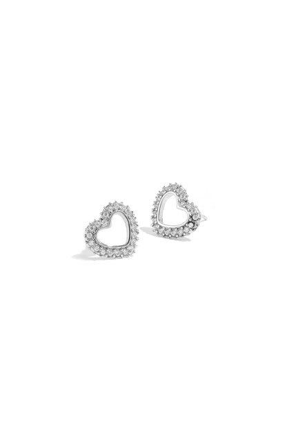 Close-up of silver-tone heart-shaped stud earrings with rhinestone accents on white background