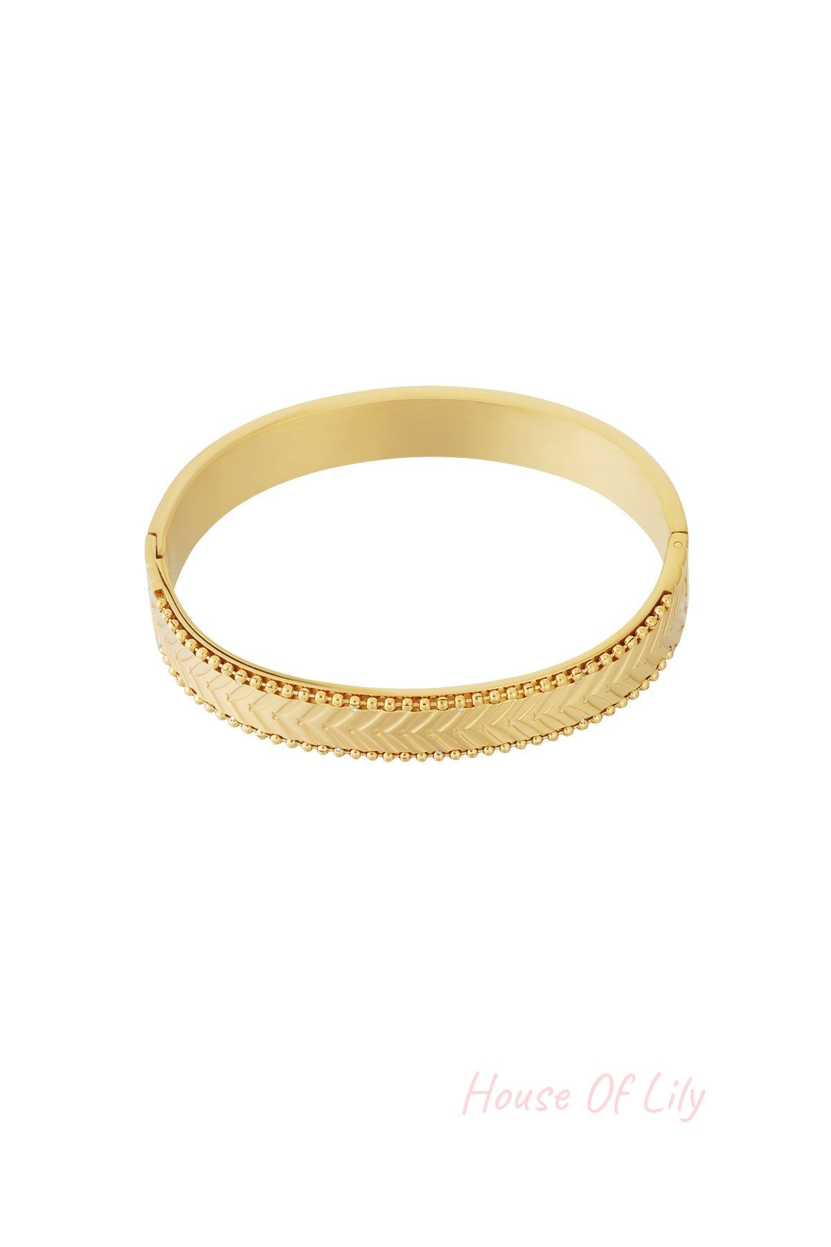 Close-up of gold chevron patterned bangle bracelet with beaded edges on white background