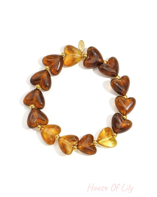 Deep berry marbled heart beaded stretch bracelet with gold accent beads on white background