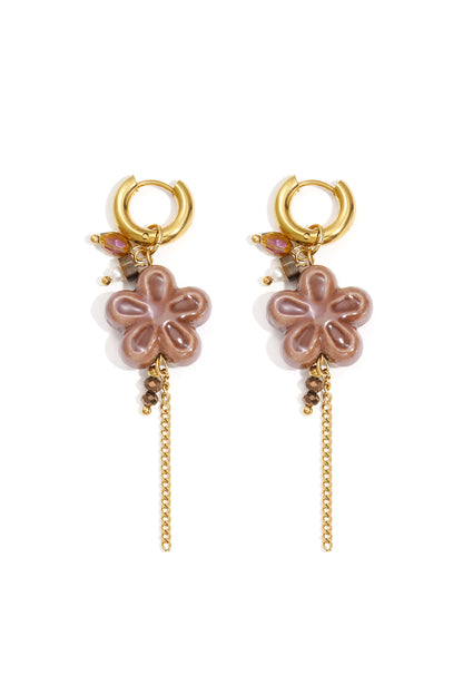 Pair of gold hoop drop earrings featuring brown resin flower pendants with small beads and dangling gold chain tassels, displayed on white background