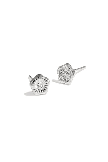 Close-up photo of silver floral mini stud earrings with rhinestone center on white background