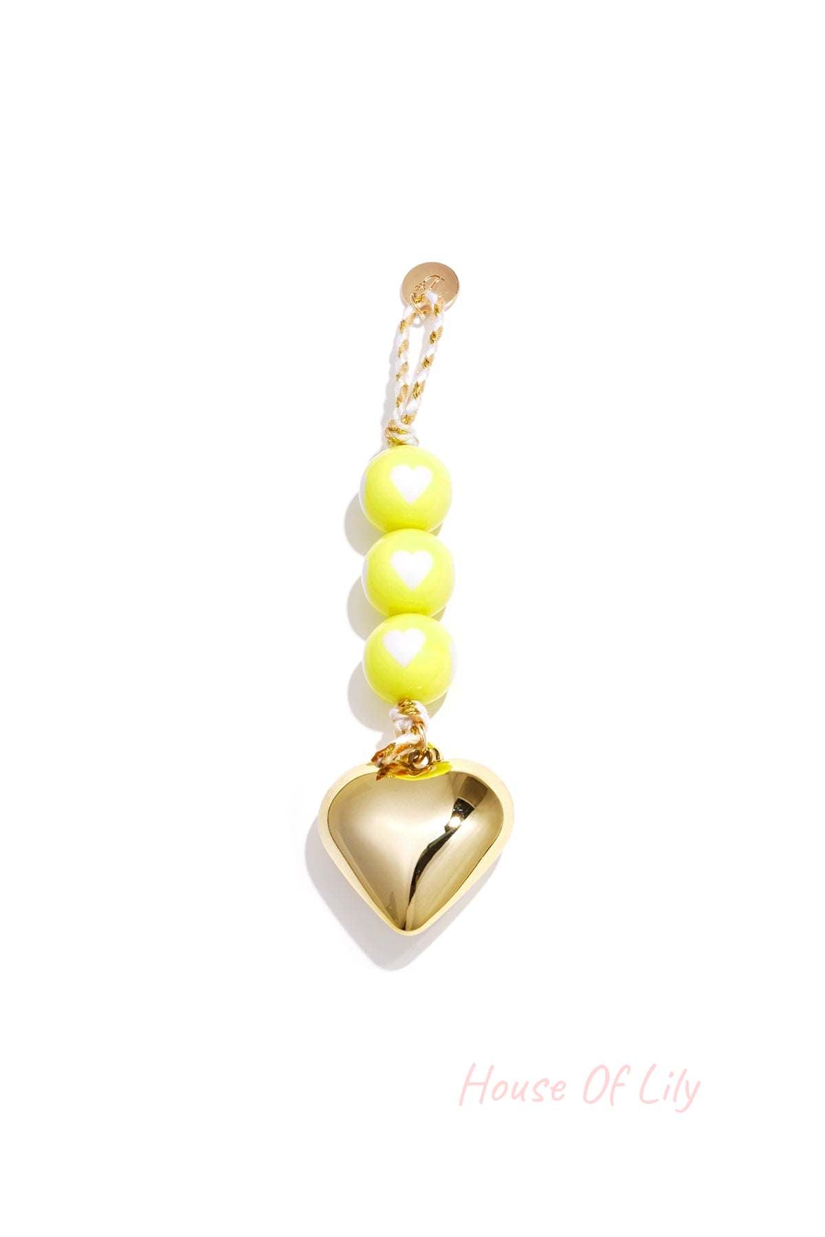 Yellow heart charm bag keychain with glossy beads and gold heart pendant on braided yellow cord