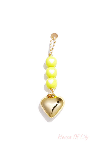 Yellow heart charm bag keychain with glossy beads and gold heart pendant on braided yellow cord